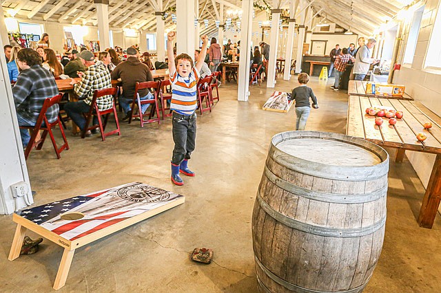 Forrest, 7, (facing camera) and little brother Maverick, 4½, (in gray sweater) enjoy the cornhole game during  
Snohomish Oktoberfest held Saturday, Oct. 19 at Dairyland in the Snohomish River Valley. The event saw some people come dressed in alpine German wear, and plenty came for the beer. åçThe event had a late venue move from being in downtown Snohomish outside to being in an indoor venue. Saturday’s weather was drenching.