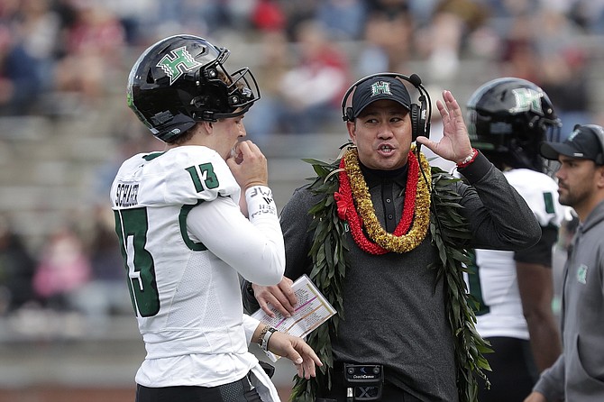 Hawaii coach Timmy Chang, right, speaks with quarterback Brayden Schager (13) during the first half against Washington State on Oct. 19.