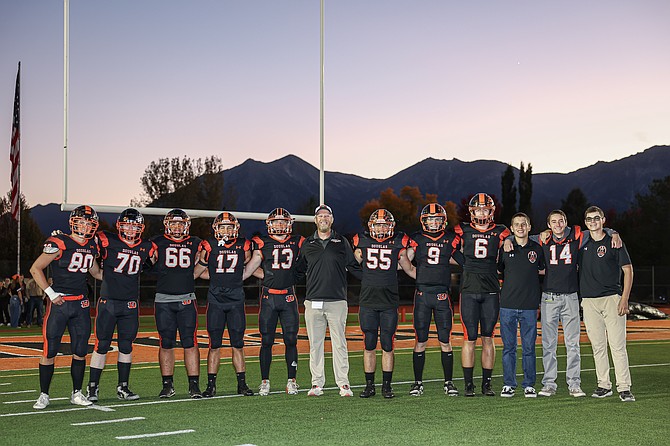 Douglas High football seniors prior to kickoff against Bishop Manogue on Thursday. From left to right are Braden Lenz, Caden Martin, Raiden Barnes, Evan Youmans, Brenton Weston, head coach Kyle Mays, Michael Cahill, Jackson Ovard, Dustin Danen, manager Mason Britton, manager Owen Mecak and manager Coby Anderson.