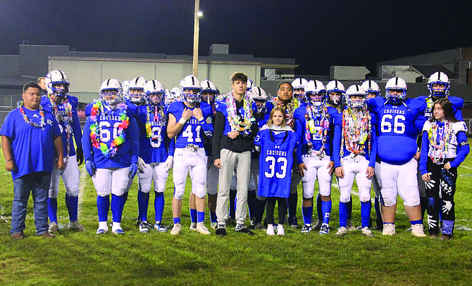 The Eatonville senior football players and managers pose for a photo with Natalie Naro, Jason's sister following the pregame ceremony honoring Jason and all of the seniors.