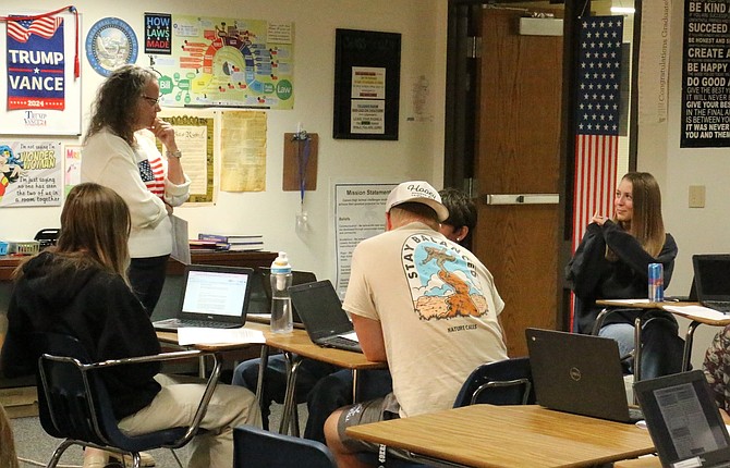 Carson High School social studies teacher Angila Golik discusses voter registration with senior Emma Drysdale.