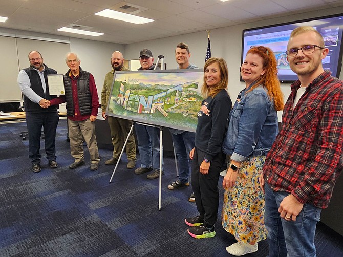 Mayor Geoffrey Thomas shakes hands with muralist David Hose at the Oct. 21 Monroe City Council meeting. At their right are council members Jason Gamble, Kirk Scarboro, Kevin Hanford, Tami Beaumont, Heather Fulcher and Jake Walker. A scale model of Hose’s mural is displayed on the stand.