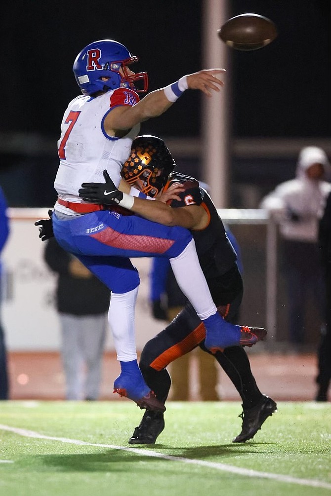 Reno High quarterback Braylon Wilson manages to get off a throw at the last moment as he’s hit by Douglas’ Dustin Danen (6). Wilson ran for four touchdowns for Reno in the win and threw for another in the Husky win.