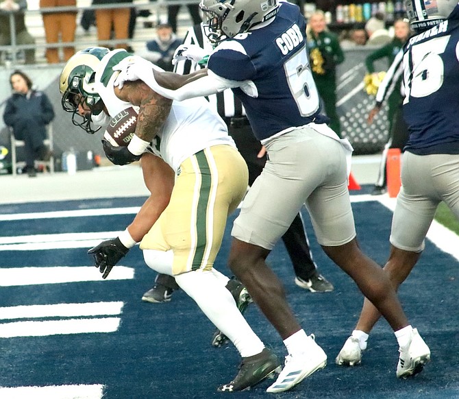 Colorado State’s Avery Morrow (25) scores in the first quarter, with Nevada’s Keyshawn Cobb hanging on, during Saturday’s game at Mackay Stadium.