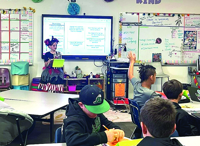 Student volunteer Gloria Wood reviews the answers to the bell ringer activity at Churchill County Middle School as teacher-of-the-day in Courtney Aguilera’s class.