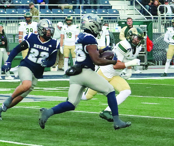 Ky Woods (25) looks for running room against Colorado State with Denton Hawkins (22) trailing behind on Saturday.