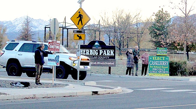 Supporters of opposing school board candidates at the Douglas County Community & Senior Center as the sun goes down on Election Day.