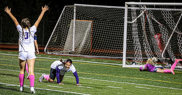 Lake Stevens forward, junior Keira Tupua, center, on the ground, shouts with joy as her shot slips past the fingers of Glacier Peak goalkeeper freshman Malia Whitaker Vogt during first half play on a rain drenched evening on the GP home pitch. Teammate junior Cora Jones joins the celebration with arms raised. Lake Stevens senior Kyra Miesel scored minutes later to keep the Vikings undefeated in the match, 2 - 0, and for the season. The #2-seeded Vikings move onto playoff quarterfinal matches. 
Lake Stevens has had a perfect season record of 11-0 league, 14-0 overall this year. They’re playing Skyline this Wednesday, Nov. 6.
Glacier Peak (6-5 league, 7-7 overall) made it into first-round districts in the 11th seed, but were summoned out by sixth-seeded Lake Washington with a 0-4 loss. Jackson and Kamiak also got knocked out in first-round districts, both in upsets.
In 3A soccer:  The No. 1-seeded Snohomish Panthers will see their first Districts matchup Nov. 5 after press time against the Shorecrest Scots. The Monroe Bearcats, seeded third, have romped through two rounds of Districts and face Shorewood Nov. 5 after press time.
The Everett Seagulls, seeded 10th, upset the Edmonds-Woodway team with a 1-0 victory in first-round districts before falling to Shorewood 2-1 on Saturday, Nov. 2. They have a redemption game Nov.5  after press time against the Mountlake Terrace Hawks. If they win that, the Seagulls soccer team still has a path to State at a game Nov. 7.