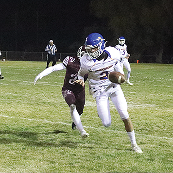 Lowry’s Ryder Huitt looks for room to run after making a catch against Elko on Friday night in Elko.