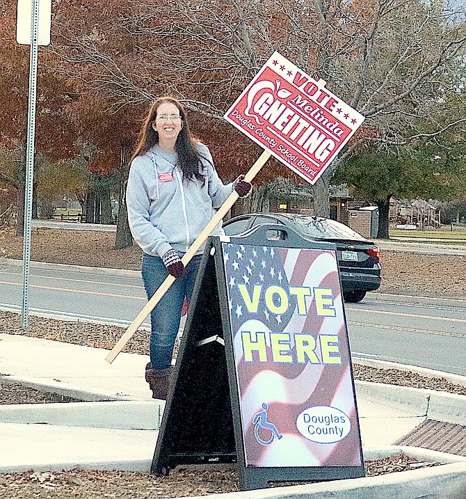 Melinda Gneiting holds her election sign at the Douglas County Community & Senior Center on Tuesday evening, just hours before the polls closed.