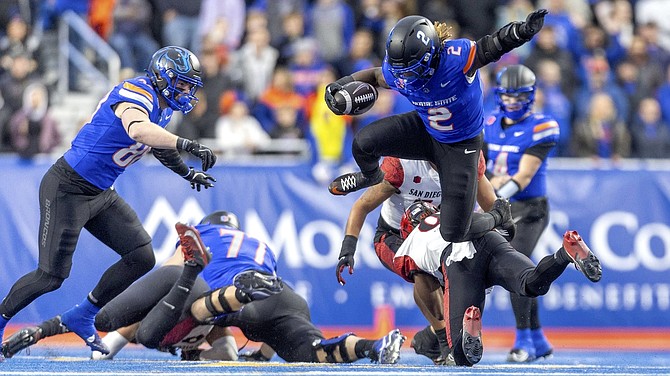 Boise State running back Ashton Jeanty (2) hurdles San Diego State’s Dalesean Staley during the Broncos’ 56-24 win earlier this month.