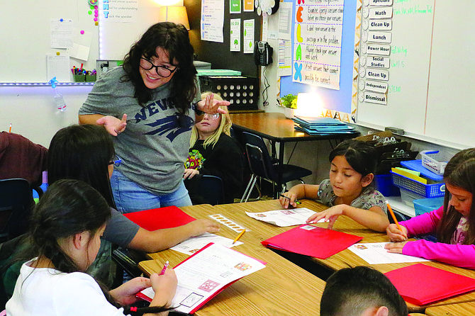 Fremont Elementary School third-grade teacher Maiya Foster works with her students on writing skills on Oct. 30.