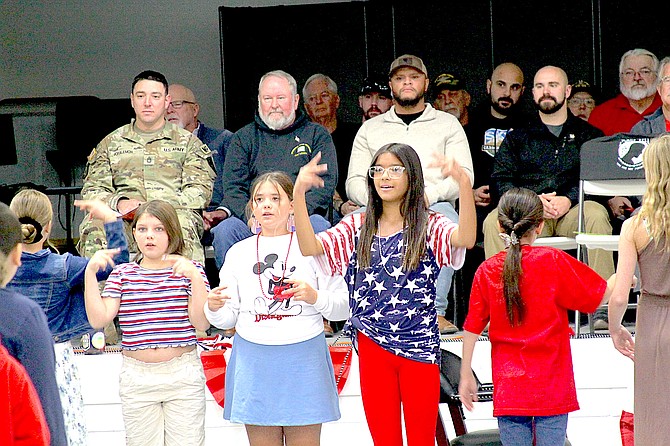 Gardnerville fifth-grade choir students, Elli Emm, Madison Persky, and Sienna Gabriel, sign “My Country Tis of Thee,” in American Sign Language during the Veteran’s Day assembly on Wednesday.