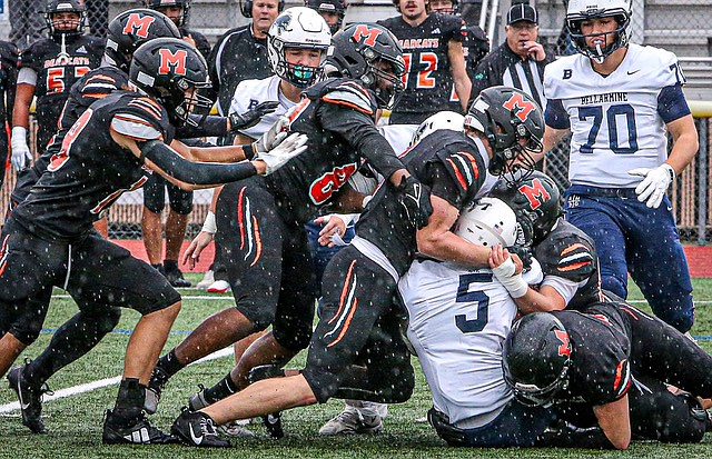 A crush of Monroe Bearcat defenders get onto Bellarmine Lions junior Elias Givins during a critical game Saturday, Nov. 9 at Monroe’s home field to decide which team advances to state. The Lions came to play, and their 35-41 loss was closer than this photo would indicate.  
The Bearcats opened the scoring in the first period but the Lions came back and came back yet again in the see saw first half. Neither team scored in the second period.  In the third quarter Monroe outscored the Lions 14 - 6, but the Lions came back in the final period to bring in 16 points to Monroe’s 13. Monroe had enough of a lead to maintain the win.
Monroe will enter the first round of 3A State seeded 14th, and will face No. 3-seeded Eastside Catholic on Eastside’s home field in Sammamish on Saturday, Nov. 16. The Stanwood Spartans also got into State, and are seeded 16th. They may be trampled by No. 1-ranked Bellevue at a game not yet formally scheduled.
In 4A, the Lake Stevens Vikings entered State in the No. 6 seed. They’ll face No. 11 Mead High School in a game on Lake Stevens’ field Saturday, Nov. 16 at 2 p.m. Lake Stevens and Arlington are the two Snohomish County schools in the State tourney.
In 2A, the Archbishop Murphy Wildcats entered State after taking a 59-7 victory over Bremerton Nov. 9. The Wildcats entered in the No. 5 seed and will face Orting.  As the higher seed, it is expected Archbishop Murphy would have the home field.