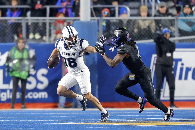 Nevada receiver Marcus Bellon (18), a former Truckee star, fights off Boise State safety Rodney Robinson during the Wolf Pack’s conference game Saturday.