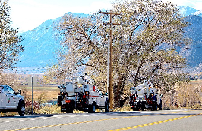 NV Energy crews clear power lines along Jacks Valley Road north of Genoa before re-energizing them after a public safety outage during the previous day's red flag warning.