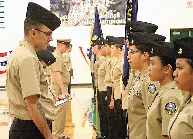 An active-duty sailor begins his inspection of one of the platoons.