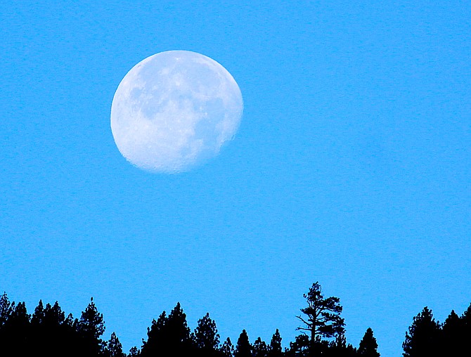 The moon sets over the Carson Range on Monday morning.