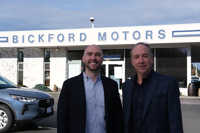 Jason and Mike Bickford stand for a photo in front of their family’s Ford dealership in Snohomish on Bickford Avenue.