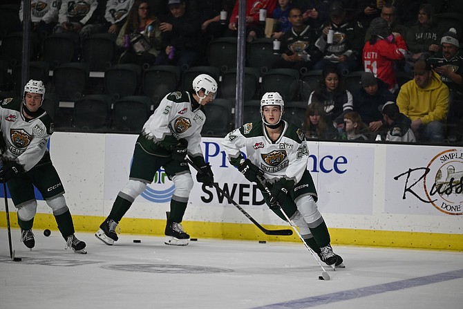 Everett Silvertips defenseman Tarin Smith, foreground, works the puck on the evening of the Nov. 22 game between the Silvertips and the Spokane Chiefs held at Angel of the Winds Arena in Everett.