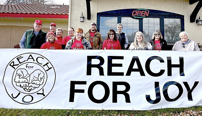 Reach For Joy members front row from left, Linda Hamer, Kaitlyn Hartman, Cindy Stapleton, Beth Robinson, Suzanne Lammay, Kara Miller, back row: John Hamer, Larry Kahar, Diana Kahar, Deb Cox, Henry Hartman, Denise Rudnick in front of Sonney’s BBQ Shack Bar and Grill.