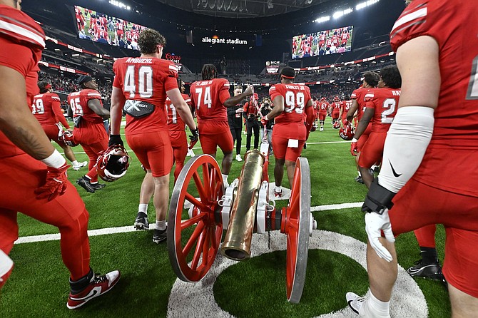 UNLV players pull the Fremont Cannon after beating Nevada on Nov. 30 in Las Vegas.