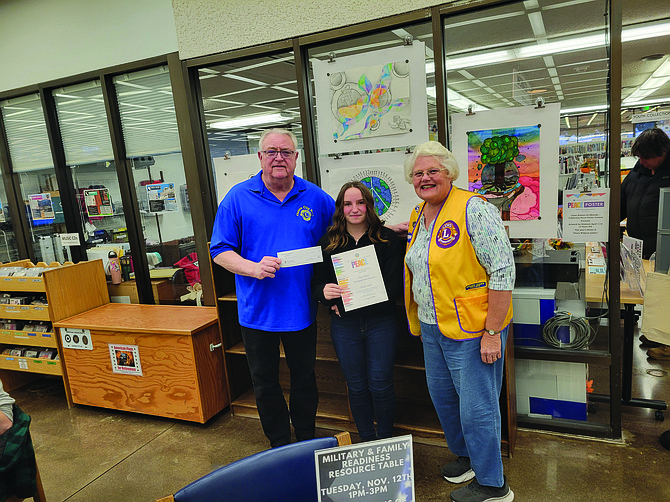 Lions’ President Ken Haskins and Lion Terry Rubald present a $50 check and a certificate to first place winner Oriah Land.