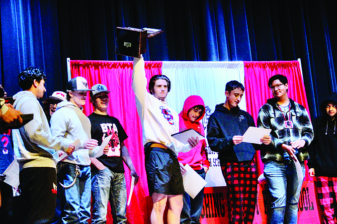 Travis Donaldson raises the 2A State football trophy surrounded by his friends and teammates- Luis Sanchez, Jeffrey Elerick, Cade Liebsack, Ayden Montes, Taylor Montes, Landon Smith and James George.