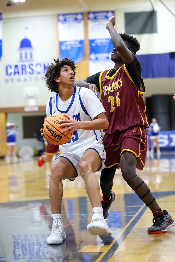 Carson High’s Kylan Jackson looks for space underneath the hoop Monday during the Senators’ 65-28 win over Sparks. Jackson had 10 points, six rebounds, four steals and two assists in the season-opening victory.