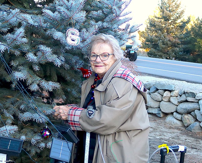 Genoa resident Marian Vassar places an ornament on the Genoa Cemetery Memory Tree on Sunday in memory of husband Kay and son David Vassar.