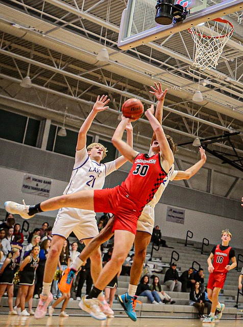 Lake Stevens Viking 6-foot-5 junior Gabe Allinson blocks Snohomish Panther 6-foot-5 sophomore Deyton Wheat under the basket during a Lake Stevens - Snohomish nonconference match up Dec. 5 in Lake Stevens.
The Vikings won 50 - 46 over Snohomish, but the game was not as close as the score might tell.  The Vikings’ tough defense often had 4 men under the Snohomish hoop elbowing for rebounds.  The Panthers spent the first period making passes in the back  court leading to  turnovers trailing 11 - 16.  They caught up in the second quarter with a 20 - 20 tie at the half.  Lake Stevens played strong offense in the third, scoring 15 - 7 and held off a Fourth Period Panther surge with continued strong defense combined with  three point baskets to take the game. Panther junior Hudson Smith  and teammate Deyton Wheat totaled for 29.