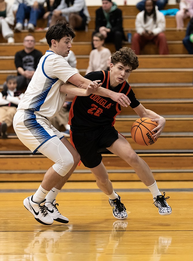 Douglas High junior guard Trent Ipsen gets around a McQueen defender in the Tigers’ season-opener. Ipsen is averaging 11.6 points per game through his first five contests this season.