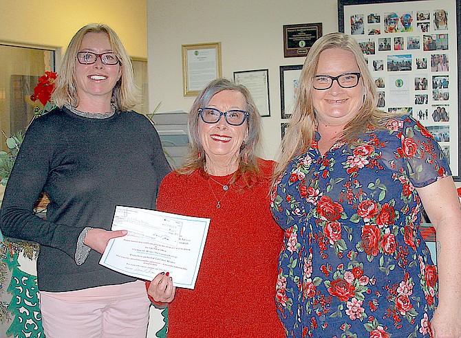 Caraon Valley Community Theatre secretary Diana Jones, center, presents a $100 check to Tahoe Youth and Family Services Executive Director Cheyanne Lane, leftm and Tahoe Youth and Family Services Client Advocate Meaghan Dobson on Monday.