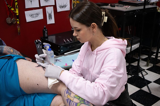 Viktoriia Veprentsova giving a tattoo to a client inside Stray Cat Tattoo on Monday, Dec. 2. Veprentsova has been working at the Snohomish shop after arriving in America about three-and-a-half months ago.