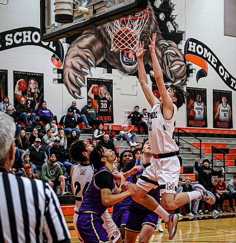 Monroe Bearcat sophomore Isaiah Kiehl follows for 2 of his 10 points during a Monroe home game against Lake Stevens on Friday, Dec. 13. Kiehl also had 6 assists on the night.
The Bearcats had five players in double digit scoring and showed a tough defense to roll over the Lake Stevens Vikings 79 - 49.  
 The matchup started unusually, with no tip off but the Bearcats taking an unattended free throw with no opposition player at the line, and then the ball was tossed into play. A referee told this photographer that in the warm up period a Lake Sevens player 
had “hung on the basket rim,” perhaps causing a rule infraction leading to the unusual game start. 
The Bearcats stand at 5 - 0 on the season. The 2 - 3 Vikings were led by David Freeman on 15 points, and teammate Brody Pierpoint scored 10.