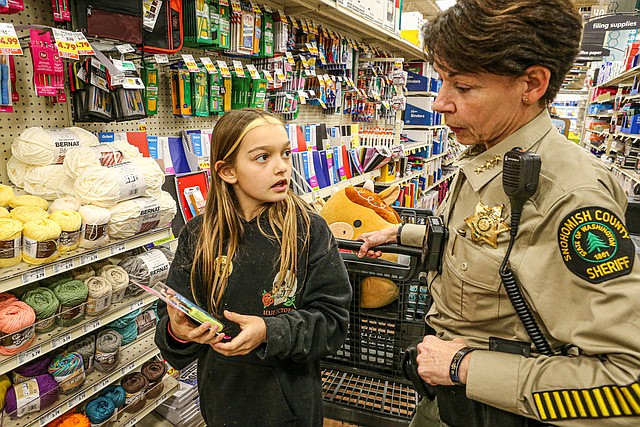 Zoë Mabery, 10, of Snohomish and Snohomish County Sheriff Susanna Johnson discuss Zoë’s purchases as part of the Snohomish Police Department’s annual Shop With a Cop event held at the Snohomish Fred Meyer Thursday, Dec. 12. 
The program was co-sponsored by the Snohomish Boys & Girls Club and the Snohomish Lions Club. Each child could choose anything up to a value of $100. Zoë said she was looking for something for her mom.
The Monroe Police Department also held its Shop With a Cop event last week at the Monroe Walmart.