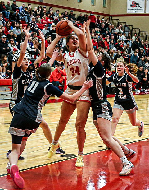 Snohomish Panther Senior Tyler Gildersleeve-Stiles pushes through heavy Glacier Peak defensive screen, lead by Grizzly junior Zoey Ritter (jersey #11), for two of her game-high 25 points in the Panthers’ win against crosstown rival  Glacier Peak 
62 - 42 on Saturday, Dec. 14 in Snohomish.  The quiet first period had the Panthers one point shy at 13 - 14 in Glacier Peak’s favor. The Panthers gained momentum in the second quarter, gaining a lead of 29 - 20.  Snohomish stretched the second half to a 20 point advantage and the fine win.  
In the evening half of a double header, the Glacier Peak Varsity Boys prevailed on the Panthers 76 - 42.