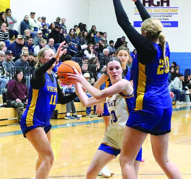 Lowry's Allison Green passes the ball in between two South Tahoe defenders in the Lady Bucks' 54-39 win over the Vikings on Friday in Winnemucca.