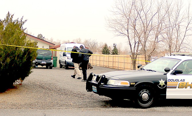 Investigators make their way into a Dennis Street home on Dec. 16 after a double shooting.