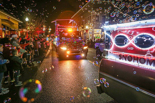 The “Snohomish Class of ‘72 Bubble Truck” owned by Mike Carver’s family emits bubbles while driven by one of the many participants in the Snohomish freestyle Christmas lights cruise that’s become an unofficial tradition in Snohomish looping around town the evening of Saturday, Dec. 21.
The cruise went off without a hitch. It began about 5:30 p.m.  There were motorcycles, cars, trucks, hotrods, customs, scooters, ATVs and whatever else could roar, honk and roll in the parade. People lined First Street for the show. Candy, Hot Wheels and stuffed animals were tossed to the crowd.