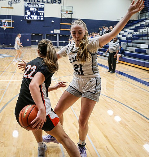 Showing a deft “behind the back” pass, Monroe Bearcat junior Mya Mercille looks for play-ing room while being covered by Glacier Peak Grizzly senior guard/post Rikki Miller during the matchup in the Grizzly Den Wednesday, Dec. 18. Glacier Peak took a revenge win over Monroe, 68 - 39.
Glacier Peak Senior  Brynna Pukis took 26 points, including 11 in the third quarter. The team played their signature tight Defense.
Monroe’s Cascadia Yates led the Bearcats with 11 points.