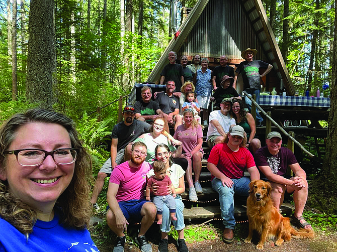 Townsend family poses in front of a cabin on their farm