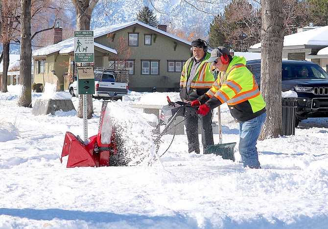 Workers clear the snow from sidewalks around Minden Park on Feb. 5, 2024, after a record 25 inches of snow fell.