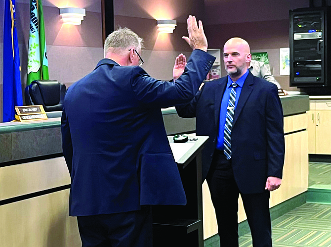 Tenth Judicial District Judge Thomas Stockard, left, swears in Ben Trotter to his second term as New River Township justice of the peace. County office holders were sworn in Monday, and the oaths were administered to elected city officials Tuesday.