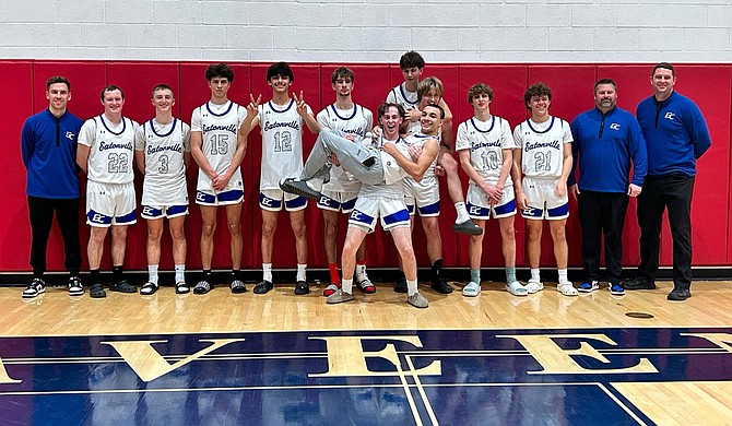 The Eatonville Cruiser boys basketball team poses for a photo and celebrate their first win of the season and Coach Josh Bennett's first victory as head coach after defeating the Tempe Prep Knights 48-44.