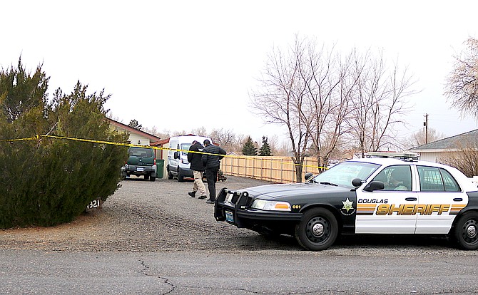 Sheriff’s investigators walk to a home on Dennis Street after a Dec. 16 shooting.