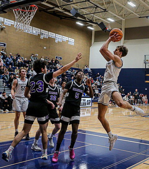 Glacier Peak Grizzly senior Jo Lee arcs his shot over the Kamiak Knights defense of #23 senior Milan Hennatian, and #5 junior Aaron Pierre during  the Grizzlies’ strong 74 - 48 win on Tuesday, Jan. 7 at Glacier Peak’s home court. The Grizzlies led the entire game with good defense under the net, strong rebounding and three-point shooting.  The Knights were held to 7 points for the first period, and couldn’t catch up later.
The Glacier Peak boys were 10-1 (4-0 league) as of Jan. 10. Kamiak, 
7-7 (2-3 league).