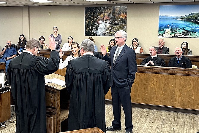 Justices of the peace Laurie Trotter and Mike Johnson are sworn in as Paul Gilbert and Richard Glasson look on from the jury box.