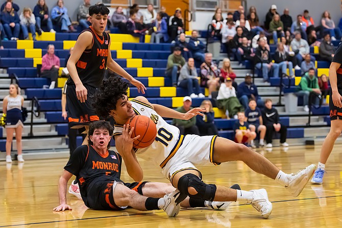 Monroe Bearcat senior wing Kieren Greear (on floor) and Everett Seagulls sophomore Santiago Salazar	tumble when Salazar and Greear tangled during the Monroe-Everett boys game Friday, Jan. 24 in Everett’s Joe Richer Gym while Monroe senior guard Myles Baumchen (standing) looks at the situation. Greear was covering on Salazar., who had the ball and was trying to get through. 
Monroe took the win 68-38 in the 3A Conference game. The Bearcats have had an undefeated conference record so far, at 7-0 conference, 15-2 season. The Seagulls are on the back foot at 2-5 conference, 7-10 season as of Sunday, Jan. 26.