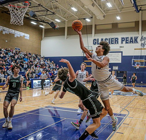 Glacier Peak Grizzly senior Jayce Nelson bowls over Jackson Timberwolf sophomore Drew Pepin during the Grizzlies strong win, 47 - 30, in the opener of a double header between Glacier Peak and Jackson on Friday, Dec. 31 at GP. 
Generous passing, 3-pointers and rebounds worked for the Grizzlies in the fast paced, physical game. The T-Wolves had cold hands and were often held out by the 3 point line in early going. 
The Grizzlies were tough in the first half, 23 - 12.  The T-Wolves Defense sparked up in the final frame but the Grizzlies remained unfazed.